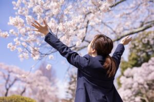 桜の下で喜ぶ受験生